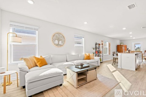 A modern living room with a white sofa and a glass coffee table.