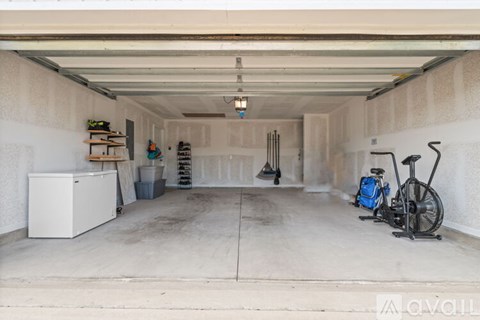 A garage with a bicycle and a fan.