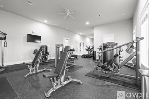 A gym with a variety of equipment including a weight bench, a squat rack, and a treadmill.