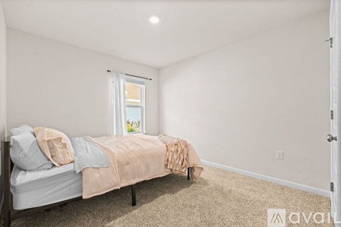 A bedroom with a bed and a window.