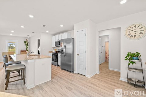 A kitchen with white appliances and a bar stool.