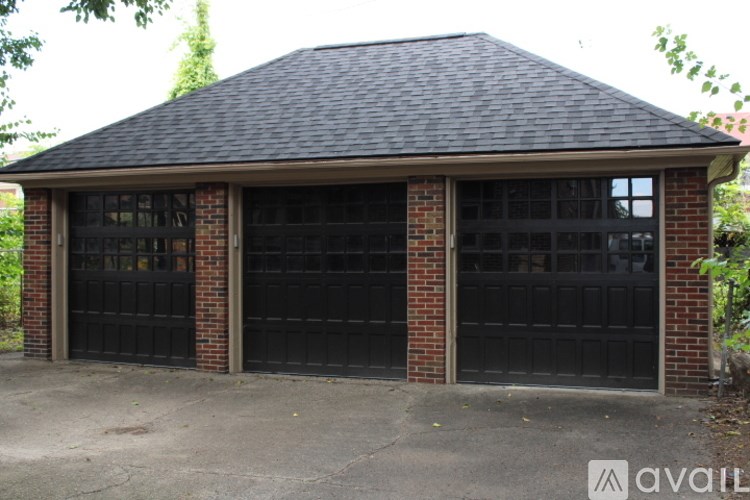 A two-car garage with brick pillars and a black roof.