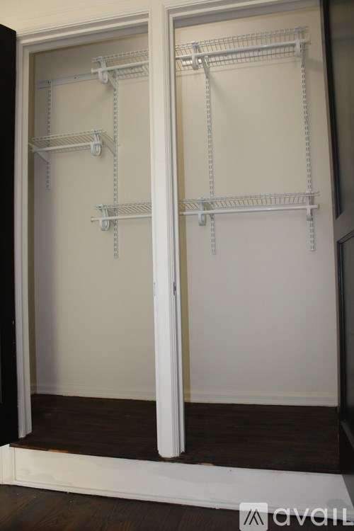 A white closet with shelves and a door open.