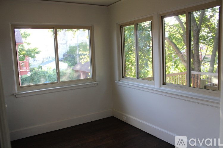 Two windows in a room with white walls and wooden floors.