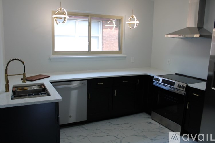 A kitchen with black cabinets and a white countertop.