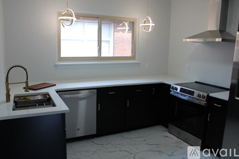 A kitchen with black cabinets and a white countertop.