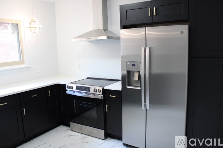 A modern kitchen with a stainless steel refrigerator and oven.