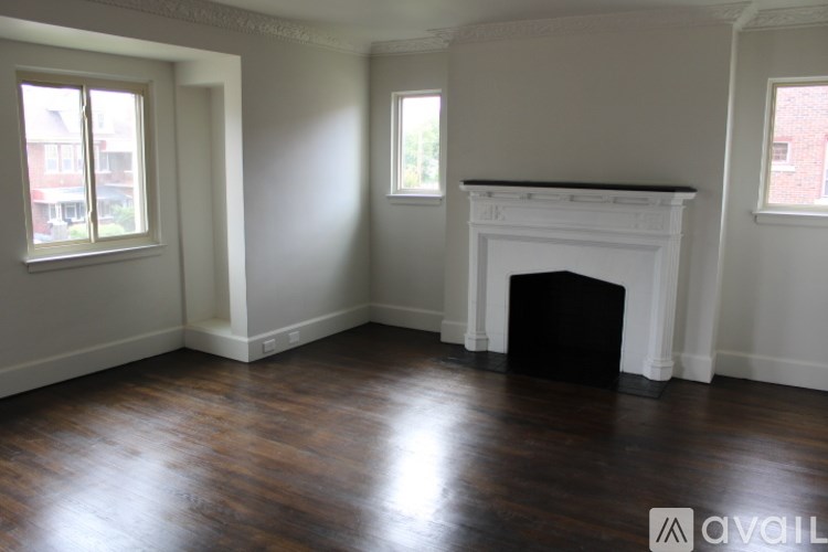 A room with a fireplace and wood flooring.