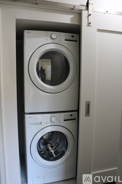 Two washing machines in a white cabinet.