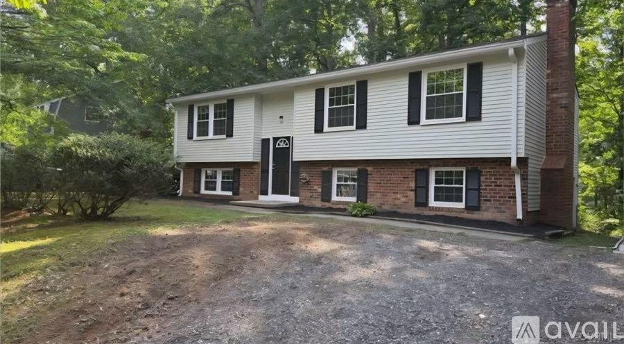 A house with a gravel driveway in front of it.