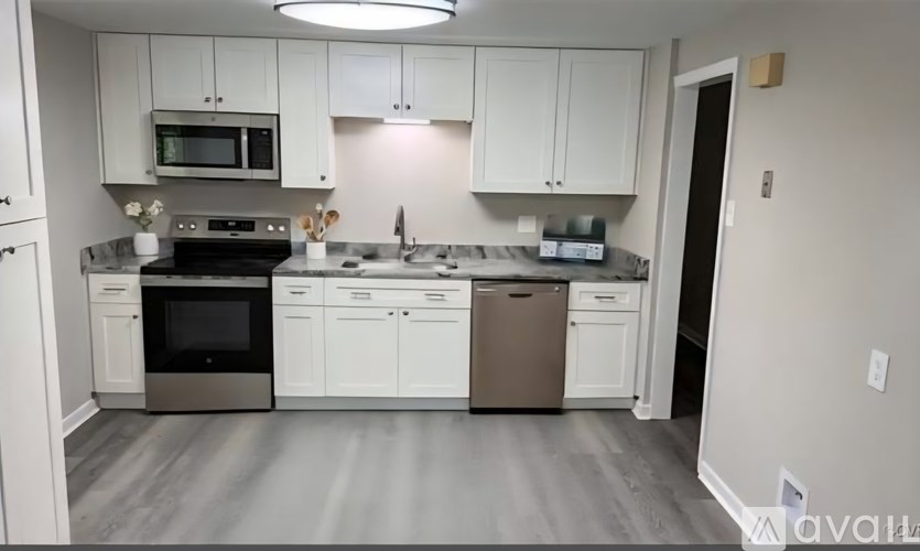 A kitchen with white cabinets and a stainless steel oven.