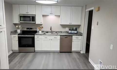 A kitchen with white cabinets and a stainless steel oven.