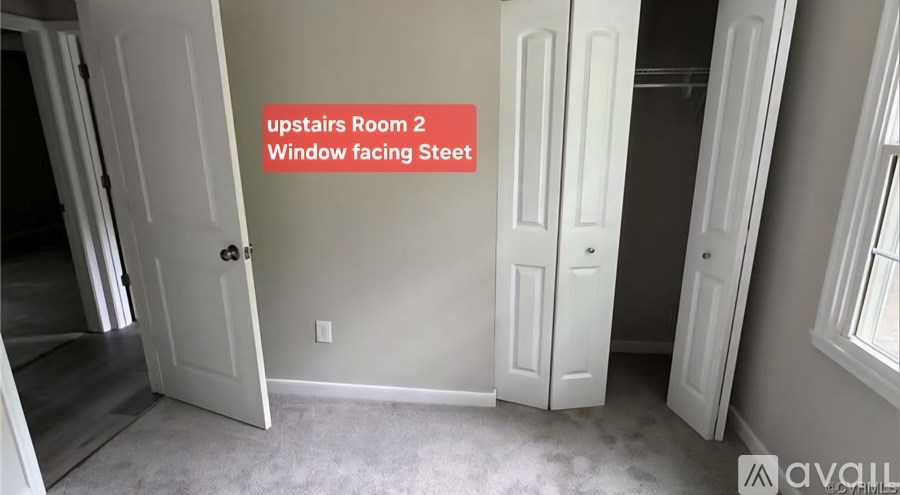 A room with a window facing a staircase.