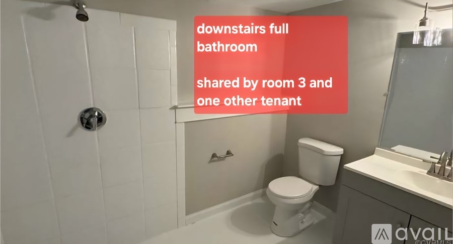 A bathroom with a toilet, sink, and shower.