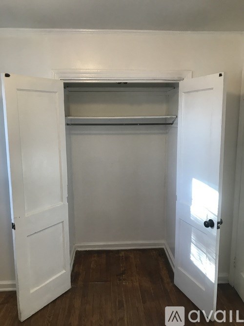 A white door with a shelf above it and a black handle.