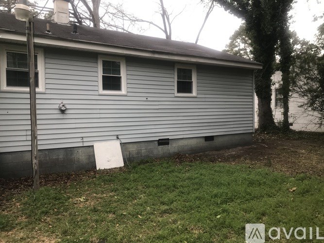 A house with a grey siding and two windows.