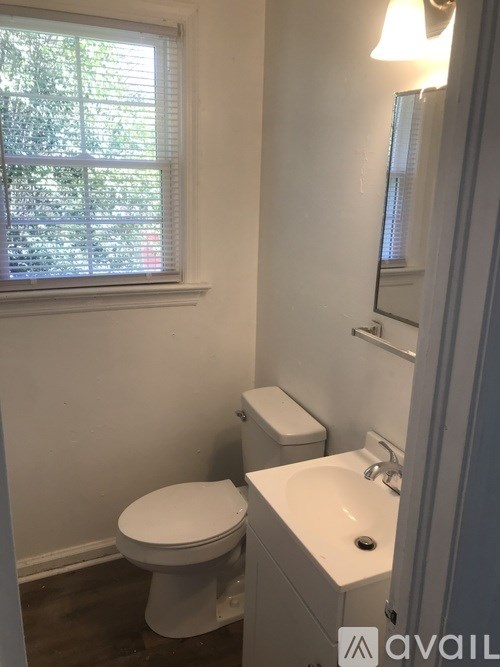 A white toilet and sink in a small bathroom.