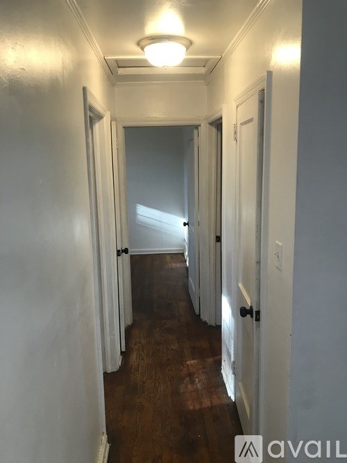 A long hallway with doors on both sides and a light on the ceiling.