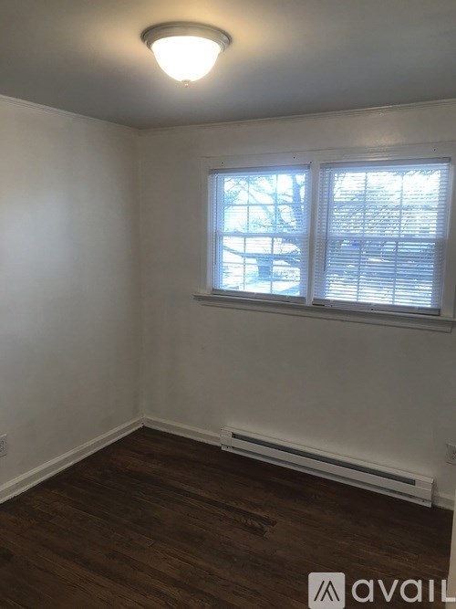 A room with a window and wooden flooring.
