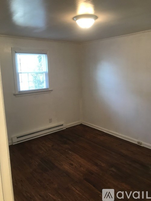 A room with a window and wooden flooring.
