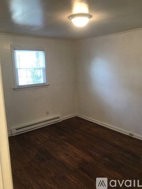 A room with a window and wooden flooring.