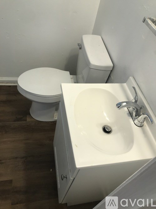 A white toilet and sink in a small bathroom.