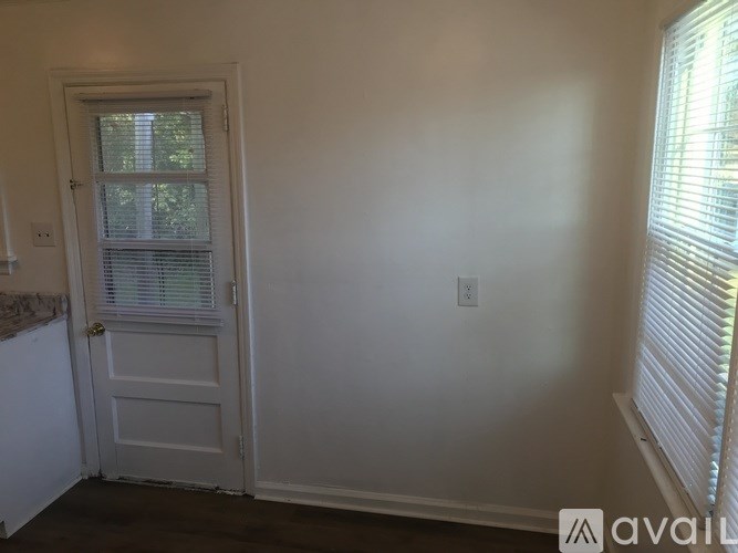 A room with a door and a window with blinds.
