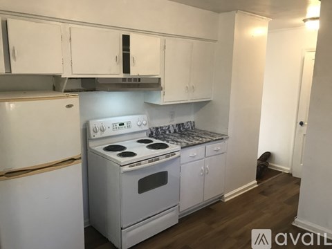 A kitchen with white cabinets and a stove top oven.