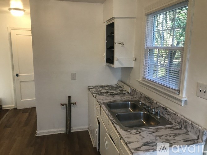 A kitchen with a marble countertop and a window.