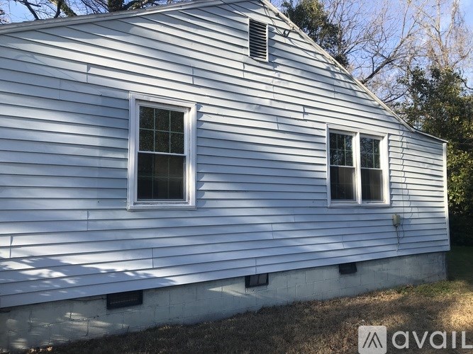 A white house with two windows and a roof.