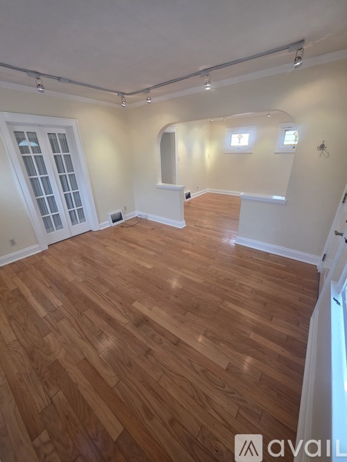 A room with wooden flooring and white walls.