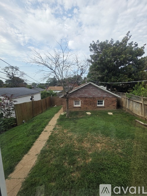 A backyard with a small house and a fence.