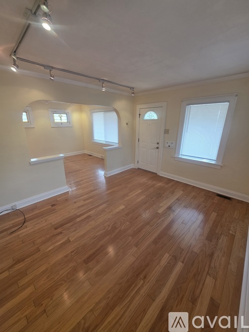 A room with wooden flooring and white walls.