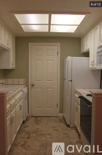 A kitchen with a white door and cabinets.