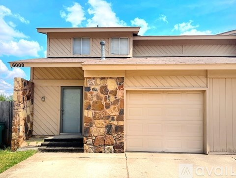 A house with a stone pillar and a garage door.