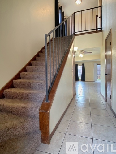 A staircase with a metal railing and a carpeted runner.