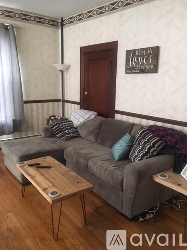 A living room with a grey couch and a wooden coffee table.