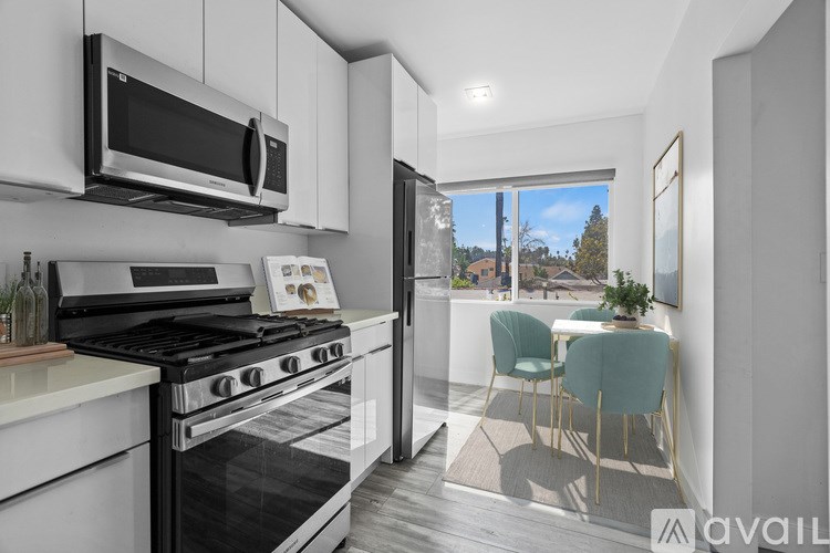 A modern kitchen with a stove, microwave, and a dining area with a table and chairs.