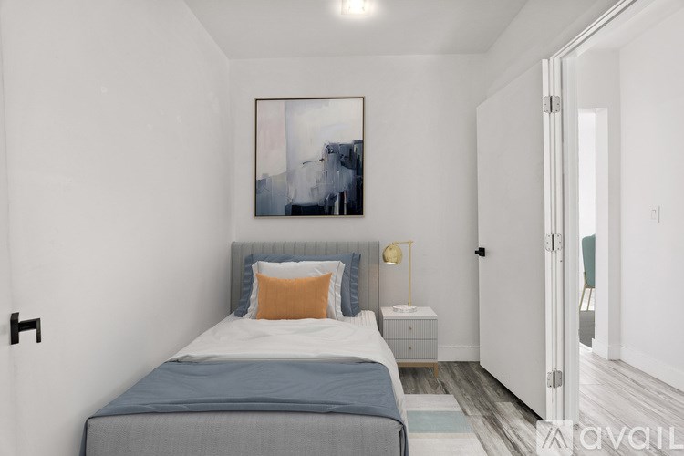 A bedroom with a bed, nightstand, and a painting on the wall.