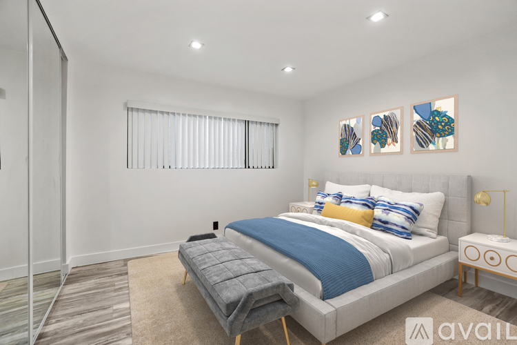 A bedroom with a large bed and a painting on the wall.