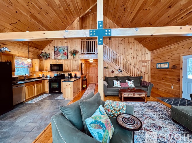 A wooden cabin with a kitchen and living room.