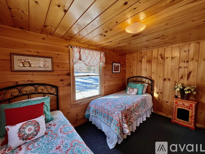 A cozy bedroom with two beds and a fireplace.