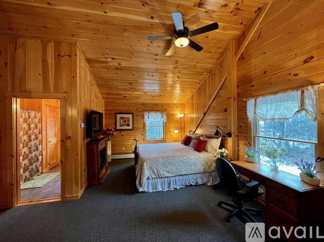 A bedroom with a bed, desk, and chair.