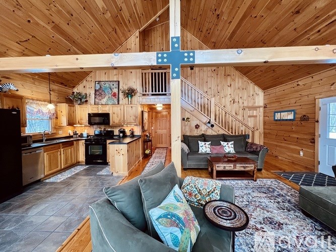 A wooden cabin with a kitchen and living room.