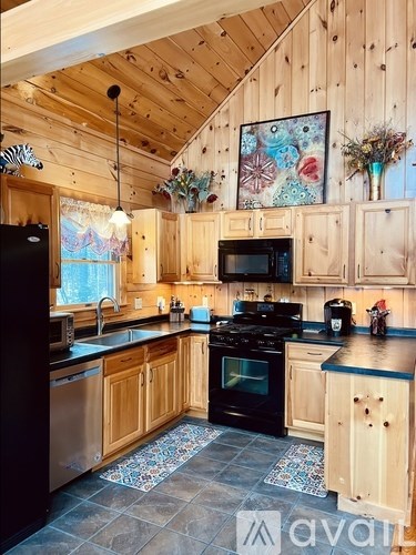 A kitchen with wooden cabinets and a black stove top oven.