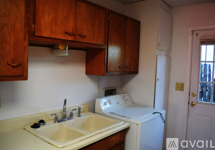 A kitchen with a white washing machine and a white sink.