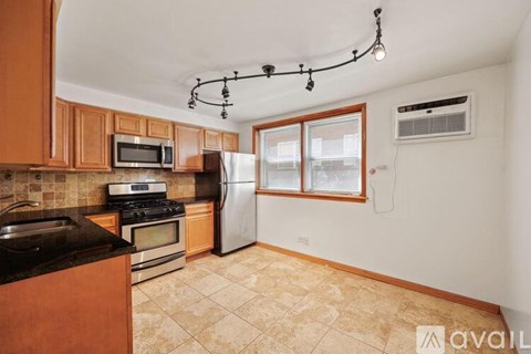 A kitchen with wooden cabinets and a black countertop.