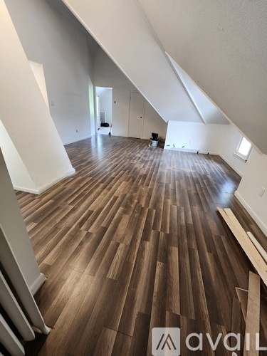 A room with wooden flooring and white walls.