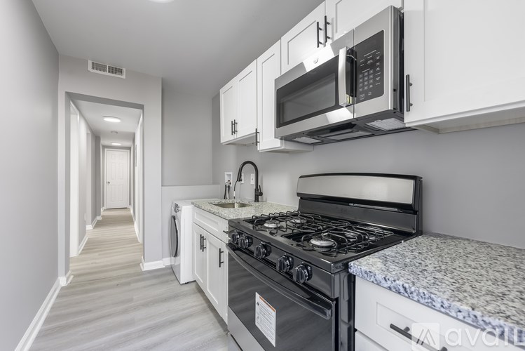 A kitchen with a stove, oven, microwave, and cabinets.