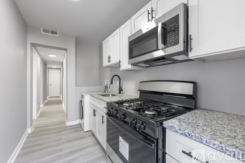 A kitchen with a stove, oven, microwave, and cabinets.